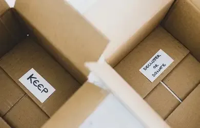 Geöffnete Umzugskartons, beschriftet mit „Keep“ und „Donate“